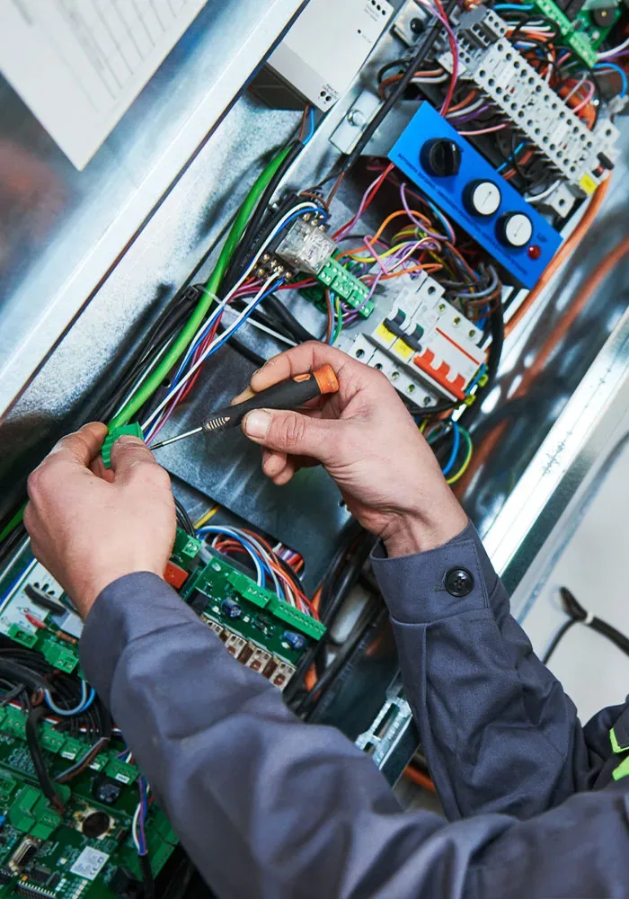 A man is working on an electrical panel.