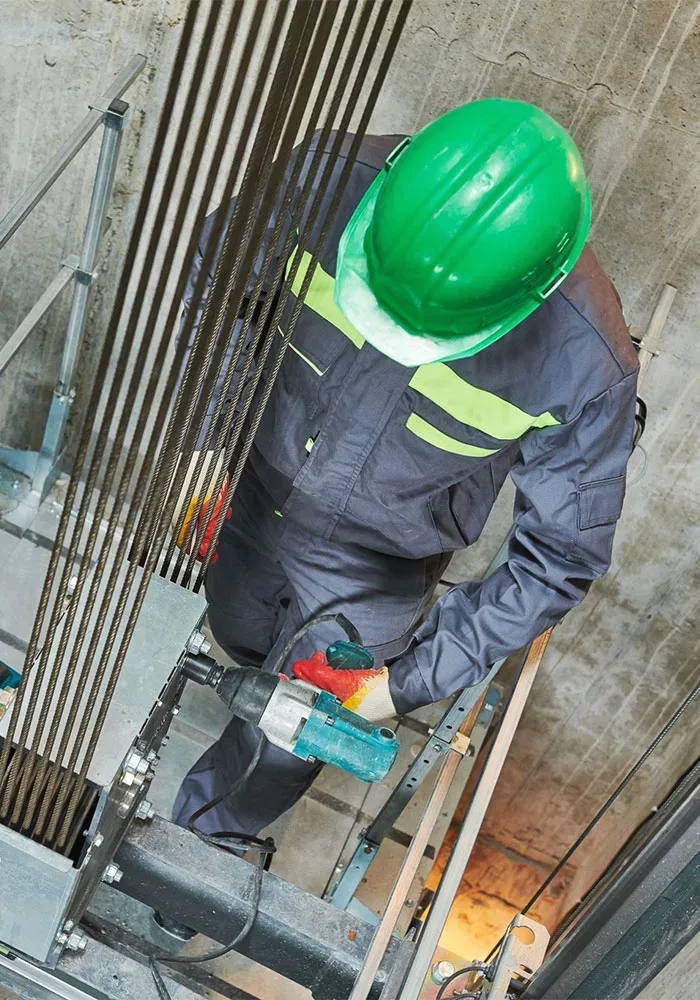 A man in a hard hat is working on a ladder.